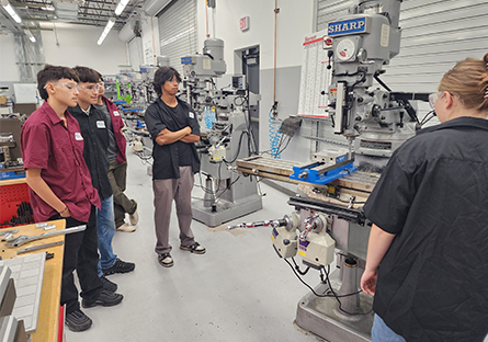 Group of students looking at CNC machine