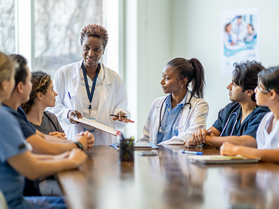 Doctor teaching nursing students around a table