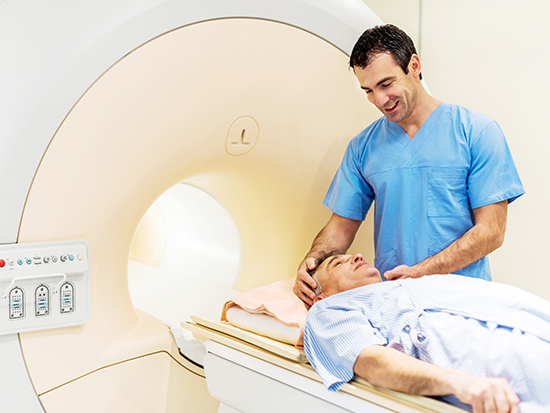 Photo of male tech standing above male patient