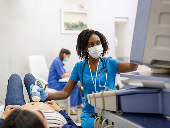 Female sonographer sitting next to female patient