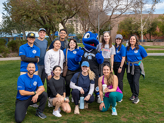 Group photo of individuals standing on green grass