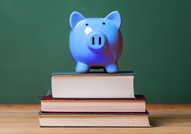 Blue piggy bank on top of a stack of books