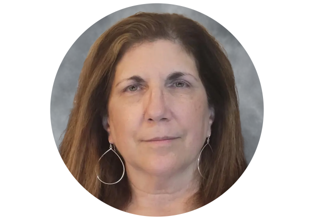 Woman with brown hair wearing large silver hoop earrings and black shirt